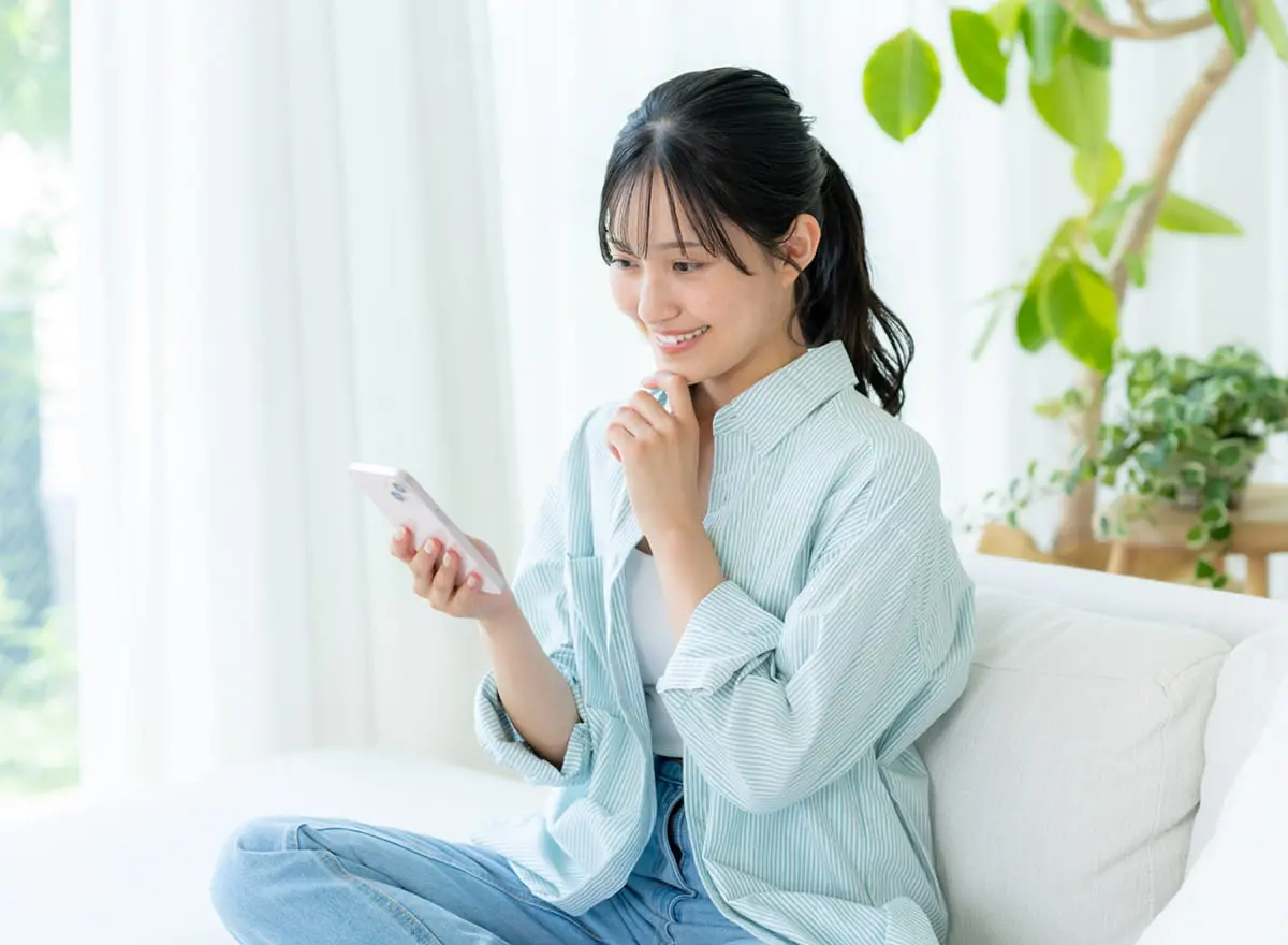 スマートフォンで限定動画を見る女性
